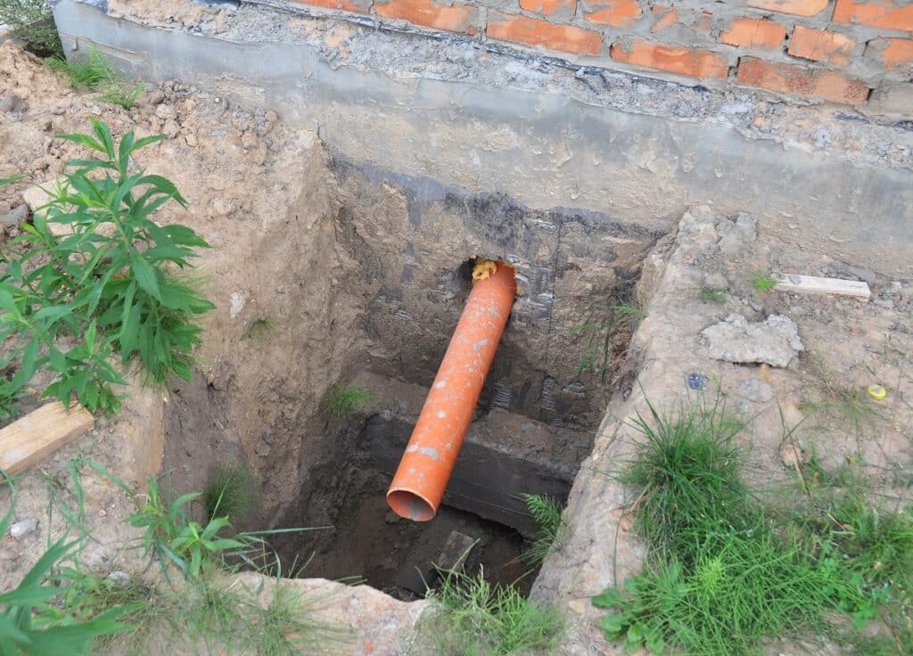 Foundation over sewer pipe drainage system.